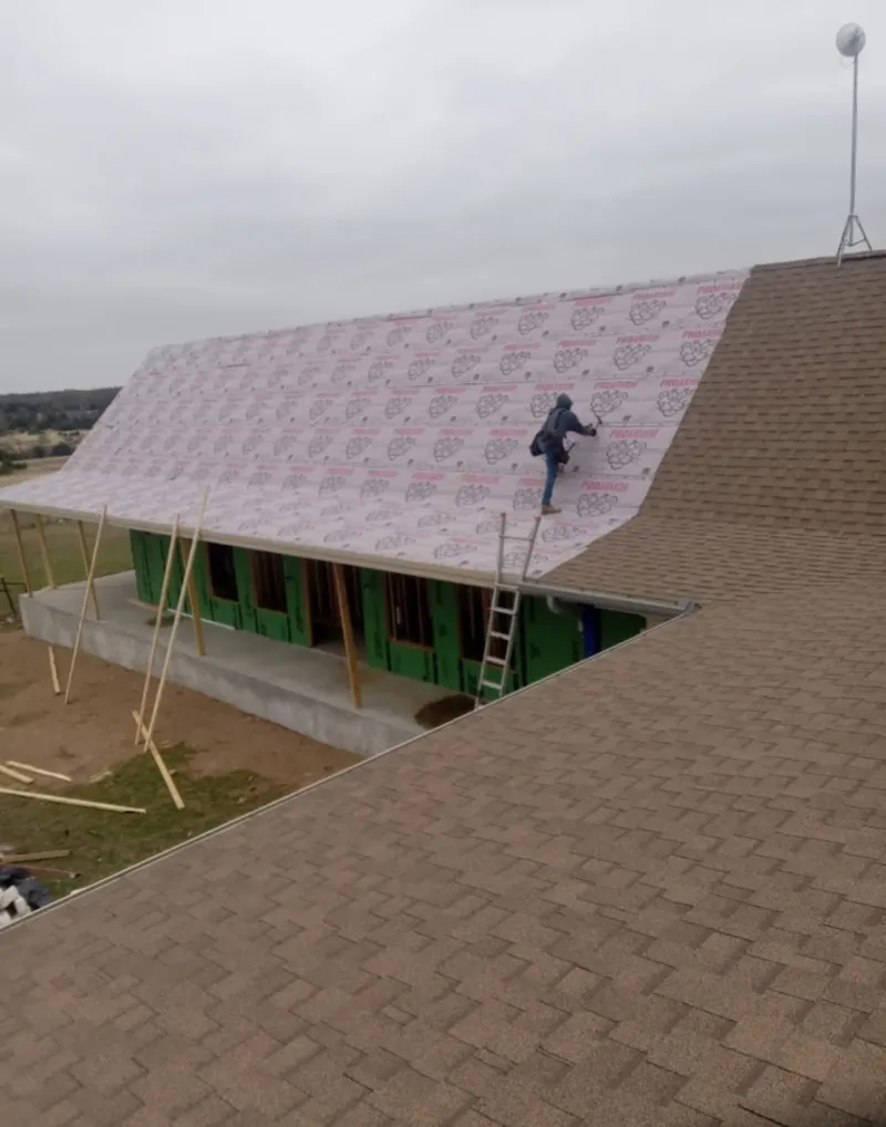 Worker preparing underlayment for a metal roof installation in Hillsborough